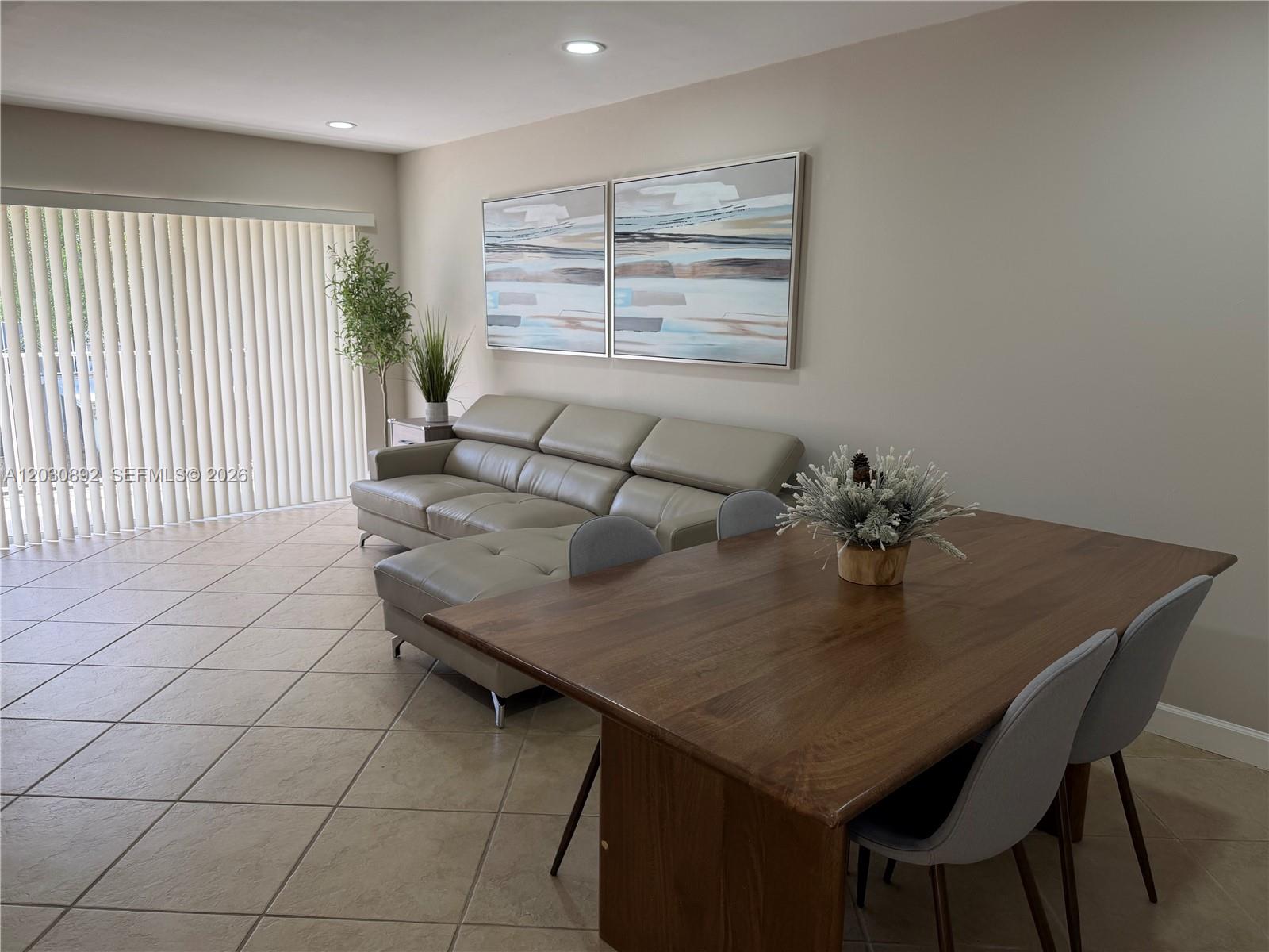 A living and dining area features tile floors, a leather sectional, and a wooden table — 4712 NW 114th Ave # 202, Doral FL 33178, DORAL, FL