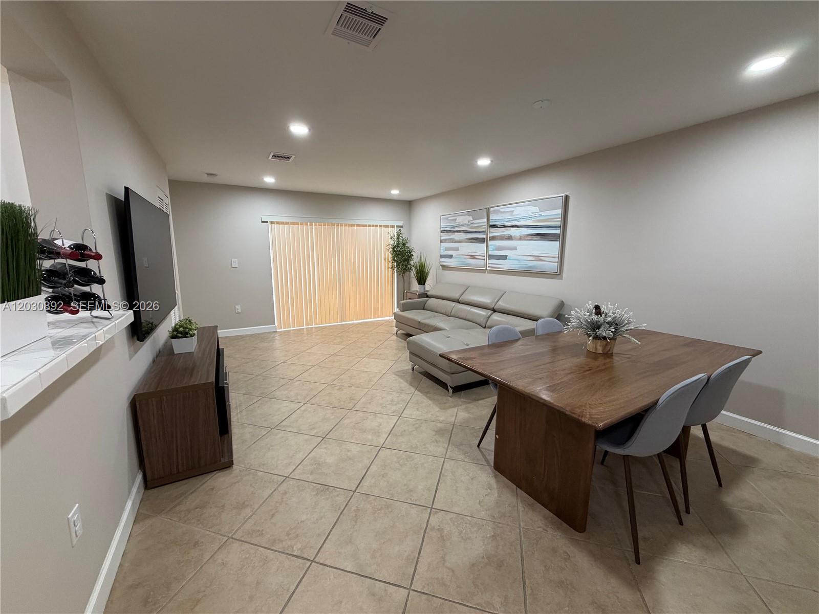 A living and dining area features tile floors, a sectional sofa, and a wooden table — 4712 NW 114th Ave # 202, Doral FL 33178, DORAL, FL