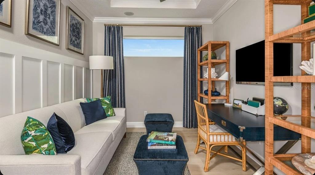 A home office features a sofa, a desk, shelving, and blue curtains by a window — 14517 DERNA TERRACE, BRADENTON, FL