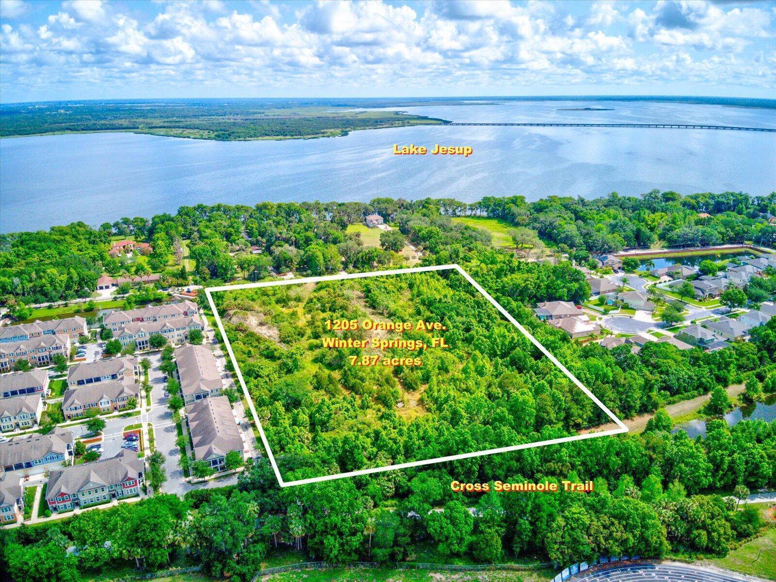An aerial view shows a large, wooded rectangular lot bordered by residential buildings and trails — 1205 Orange Avenue, FL 32708, FL