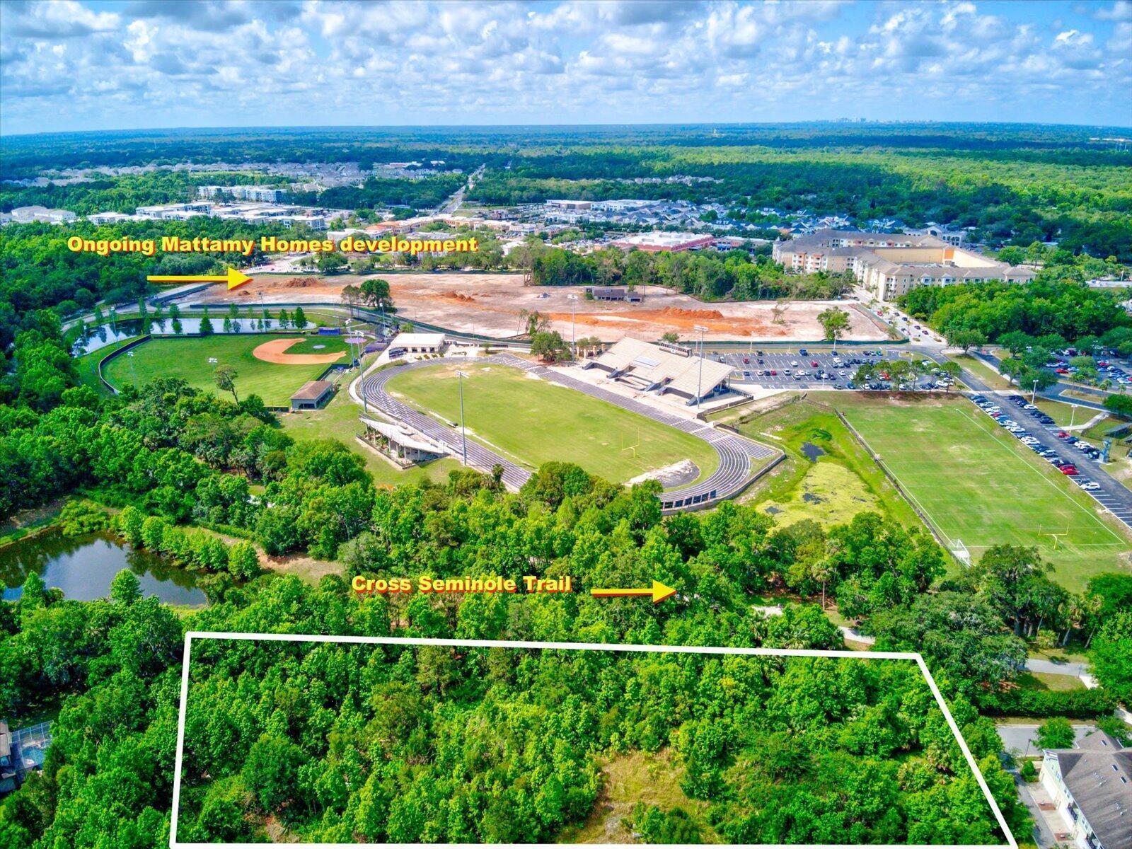 Aerial view of a wooded lot adjacent to a sports complex and a residential development — 1205 Orange Avenue, FL 32708, FL