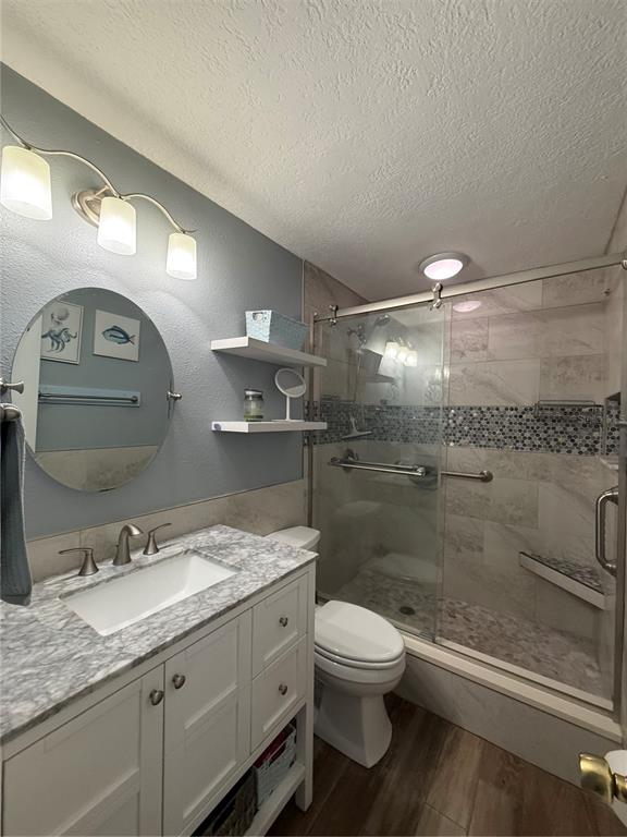 A bathroom features a marble vanity, a round mirror, and a glass-enclosed walk-in shower — 18650 GULF BLVD UNIT 316, INDIAN SHORES, FL