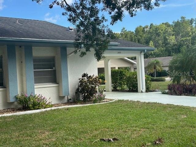 A single-story house with a white stucco exterior, blue trim, and a covered entryway — 2033 HAWKHURST CIRCLE UNIT 180, SUN CITY CENTER, FL