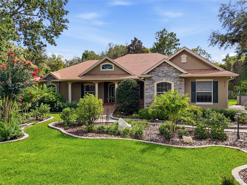 An aerial view shows a house with a pool surrounded by dense trees and lawns — 2920 CHICKASAW CIRCLE, HAINES CITY, FL