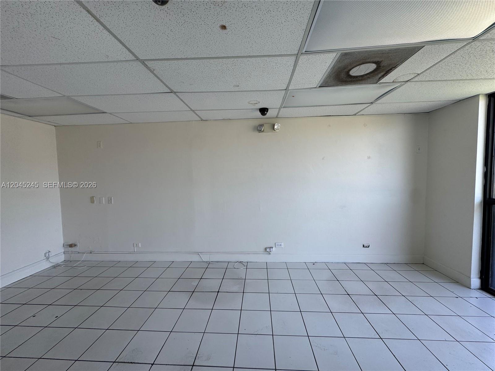 An empty office space features white walls, a drop ceiling, and white tiled flooring — 90 NW 79th Ave, Miami FL 33126, MIAMI, FL