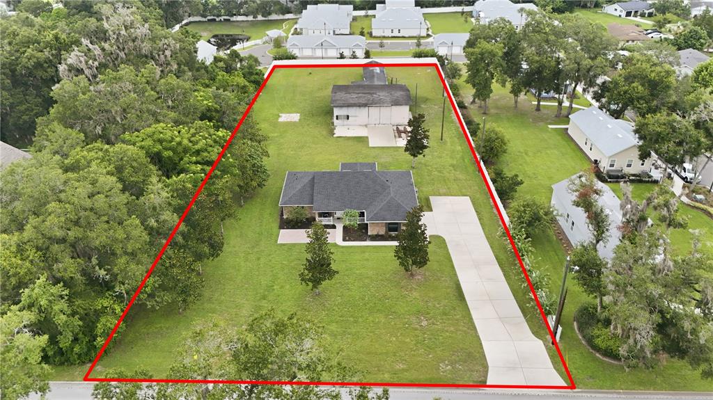 An aerial view shows a house and a detached garage on a large, grassy lot — 535 E PLYMOUTH AVENUE, DELAND, FL