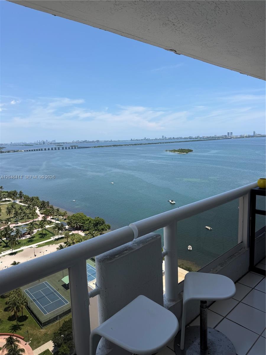 A high-rise balcony overlooks a bay with a park, tennis court, and distant city skyline — 1717 N Bayshore Dr # 2847, Miami FL 33132, MIAMI, FL