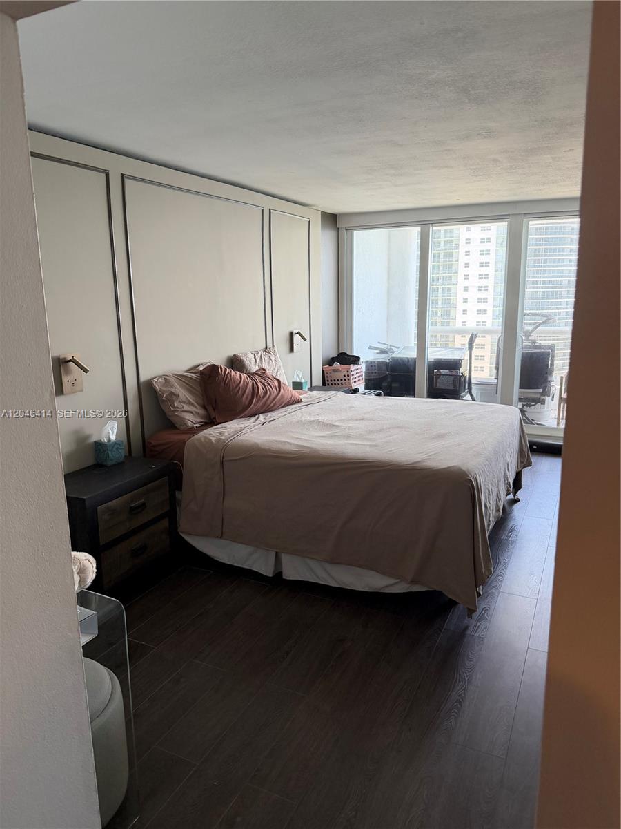 A bedroom features a bed against a paneled wall with a view of city buildings — 1717 N Bayshore Dr # 2847, Miami FL 33132, MIAMI, FL