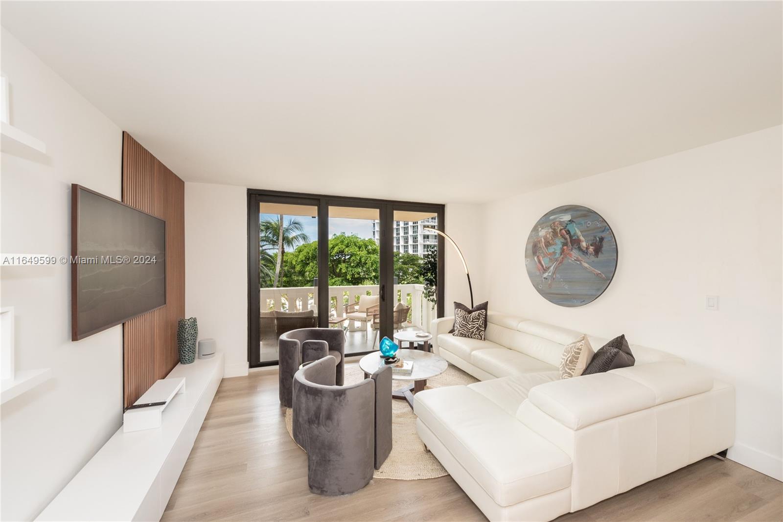 A modern living room features a white sectional sofa, two grey chairs, and a balcony — 1111 Crandon Blvd # A306, Key Biscayne FL 33149, KEY BISCAYNE, FL