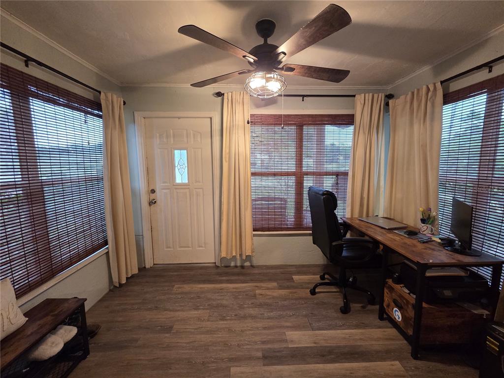 A home office features wood-look flooring, a ceiling fan, a desk, and windows with blinds — 124 E F ST, FROSTPROOF, FL