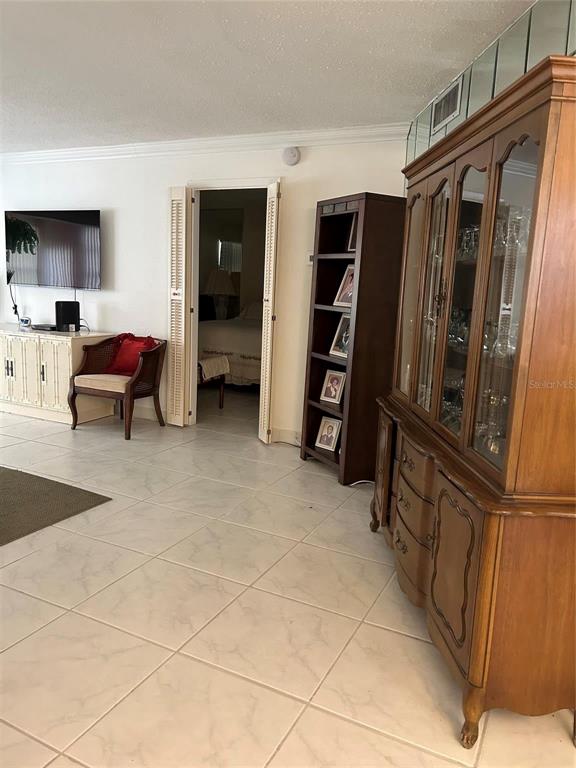 A living room features a wooden hutch, a bookshelf, a chair, and a television console — 4090 NW 42ND AVENUE UNIT 105, FORT LAUDERDALE, FL