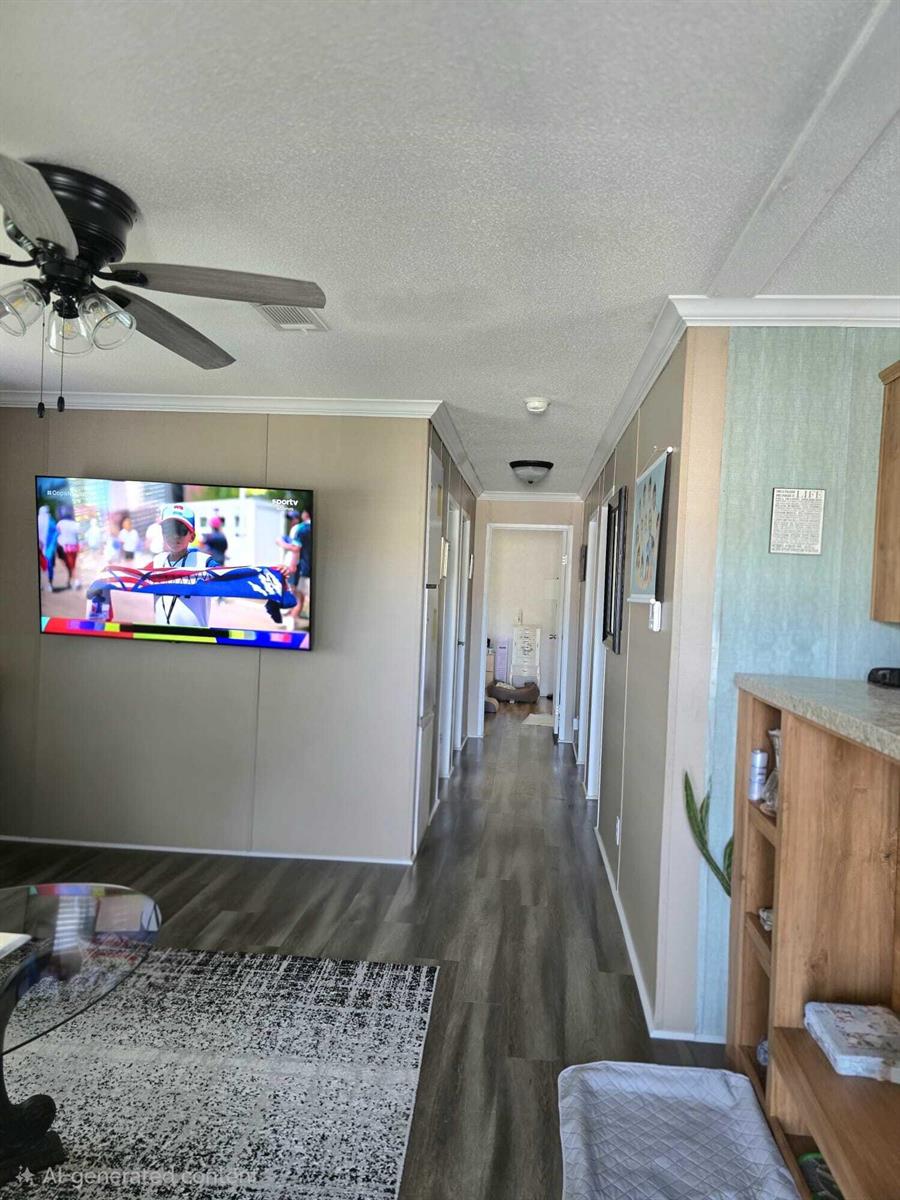 A hallway with wood-look flooring leads from a living area toward a distant room — 5003 NW 4 Terrace, Deerfield Beach FL 33064, DEERFIELD BEACH, FL