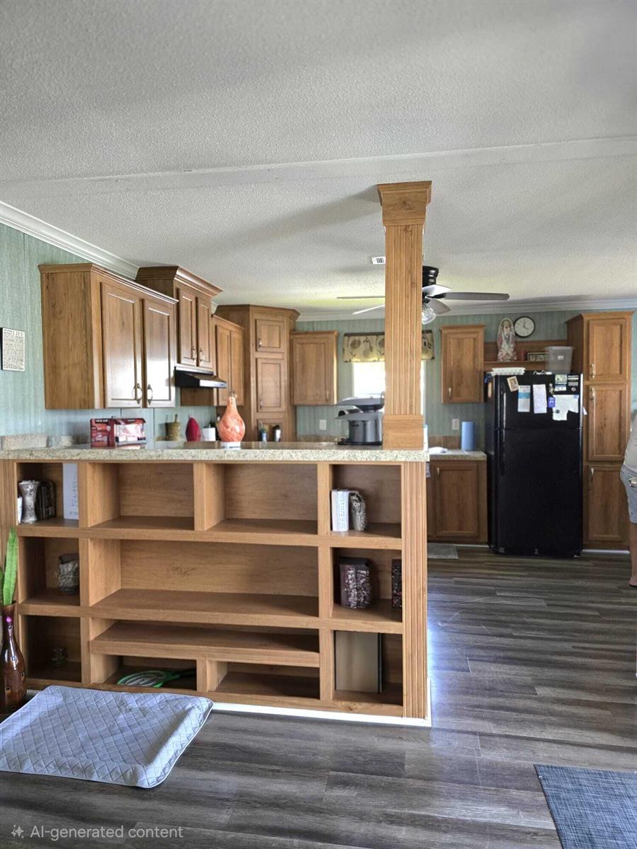 A kitchen features wood cabinets, a central support pillar, and open shelving facing the living area — 5003 NW 4 Terrace, Deerfield Beach FL 33064, DEERFIELD BEACH, FL
