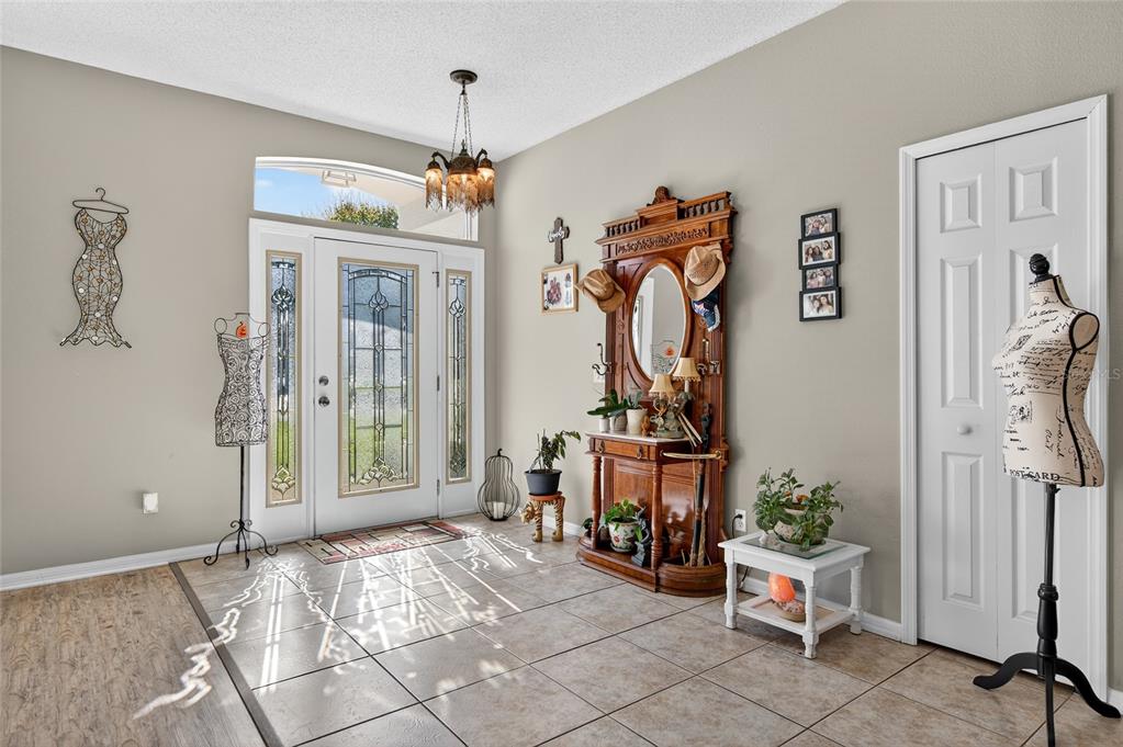 A tiled entryway features a front door with glass panels, a wooden hall tree, and mannequins — 42 BUFFALO BILL DRIVE, PALM COAST, FL