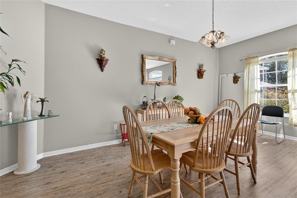 A dining room features a wooden table, spindle chairs, a mirror, and a glass console table — 42 BUFFALO BILL DRIVE, PALM COAST, FL
