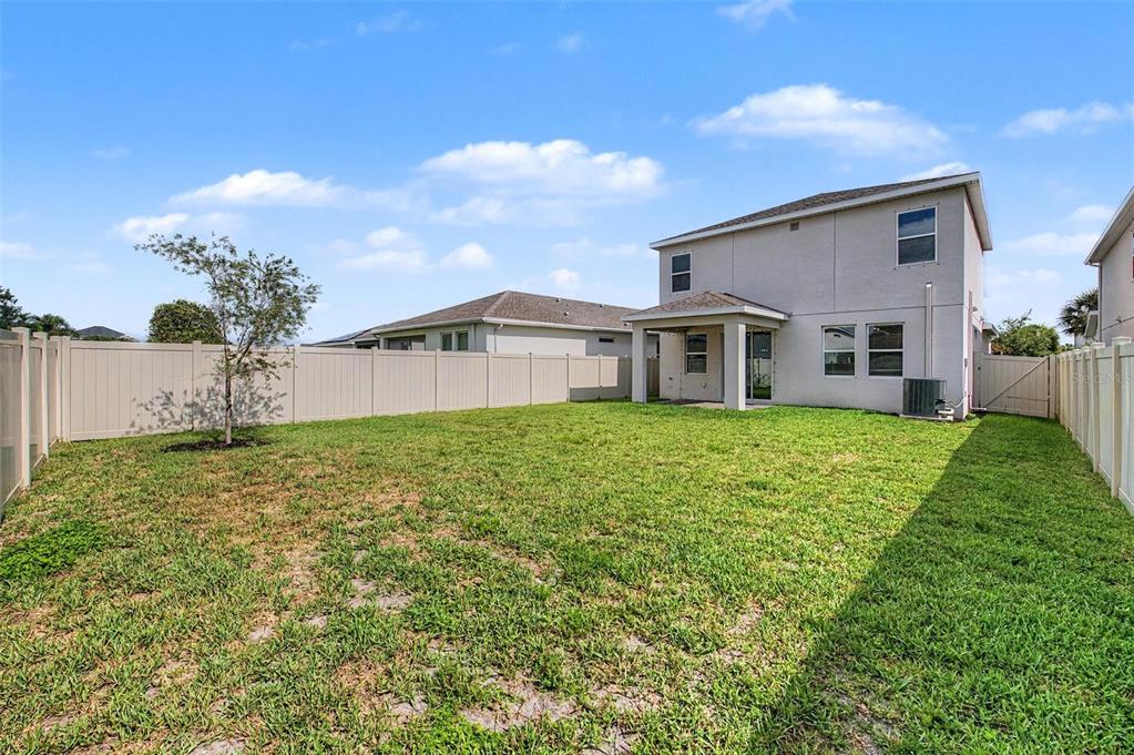 A two-story house with a fenced backyard and a small tree on a sunny day — 5435 BUNGALOW GROVE COURT, PALMETTO, FL