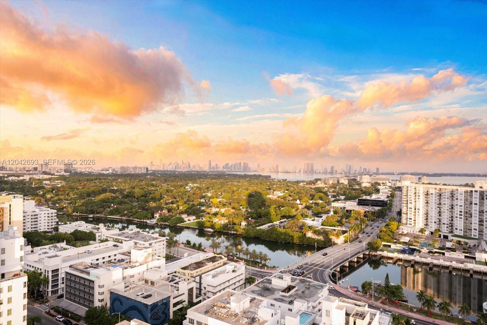 An elevated view of a city skyline, a waterway, and a bridge at sunset — 4201 Collins Ave # 2301, Miami Beach FL 33140, MIAMI BEACH, FL