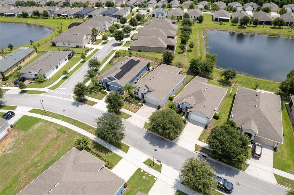 An aerial view shows a suburban neighborhood with houses, streets, and two retention ponds — 3331 SAGEBRUSH STREET, HARMONY, FL