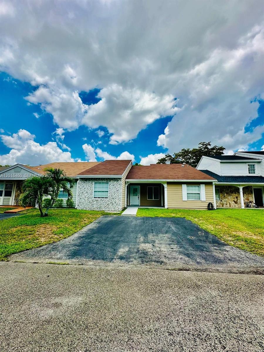 A single-story house with a brown roof, tan siding, and a stone-accented front wall — 14530 SW 142nd Ct Cir, Miami FL 33186, MIAMI, FL