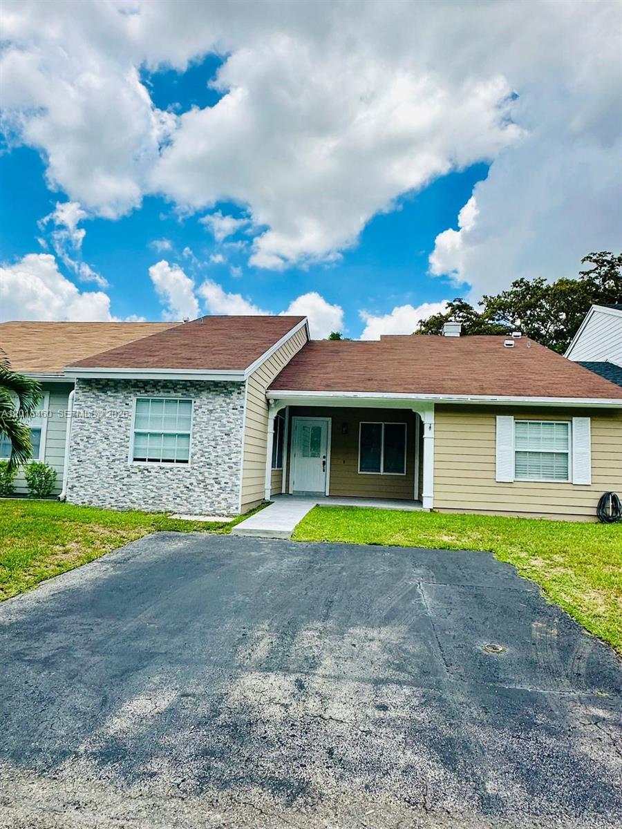 A single-story house features a stone-veneer facade, tan siding, and a brown shingled roof — 14530 SW 142nd Ct Cir, Miami FL 33186, MIAMI, FL