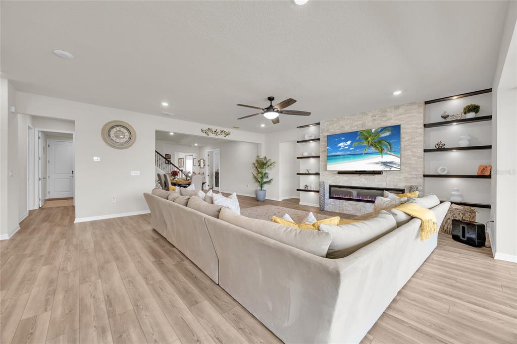 A living room features a large sectional sofa, a stone fireplace, and built-in shelving — 3286 MAINSAIL COURT, WINTER GARDEN, FL