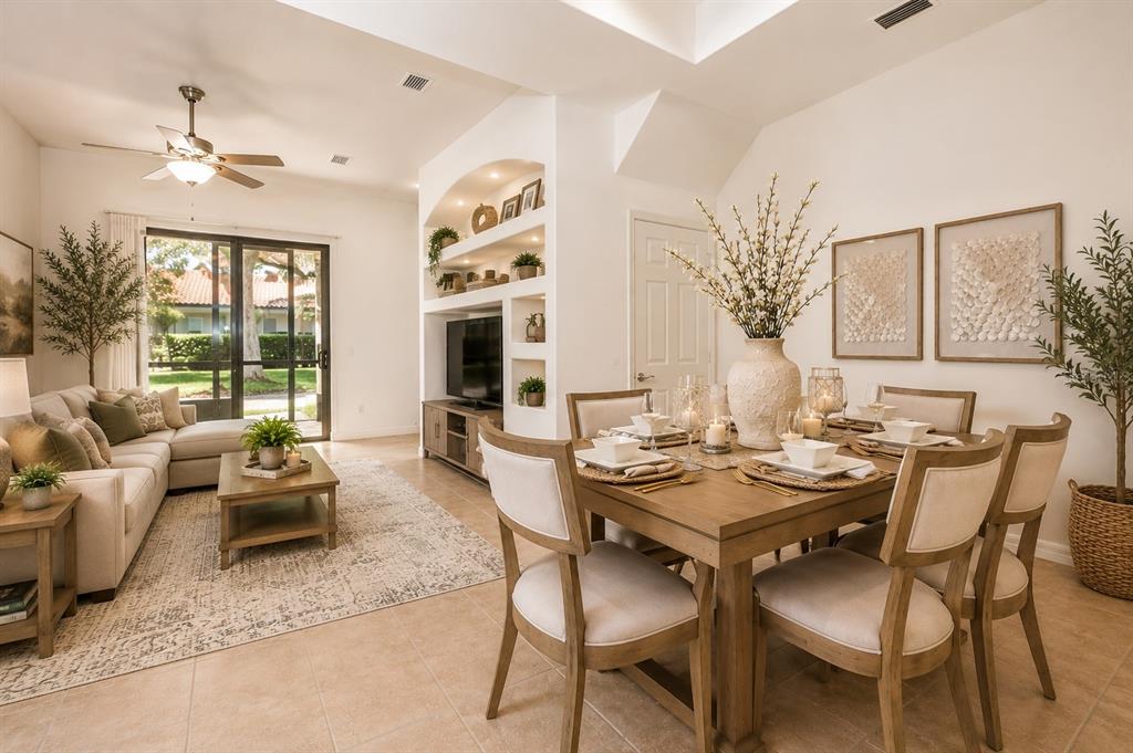 A living and dining area with tile floors, a sectional sofa, and built-in shelving — 8766 THE ESPLANADE UNIT 23, ORLANDO, FL