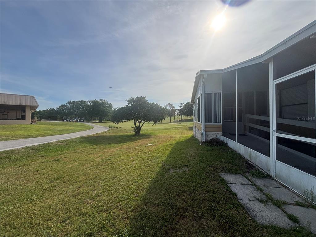 A view of a grassy yard and golf course from the side of a house — 3963 PARWAY ROAD UNIT 1325, ZELLWOOD, FL