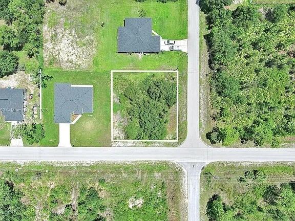 This aerial map shows a vacant, rectangular residential lot situated between two existing houses — 2500 E 10TH STREET, LEHIGH ACRES, FL