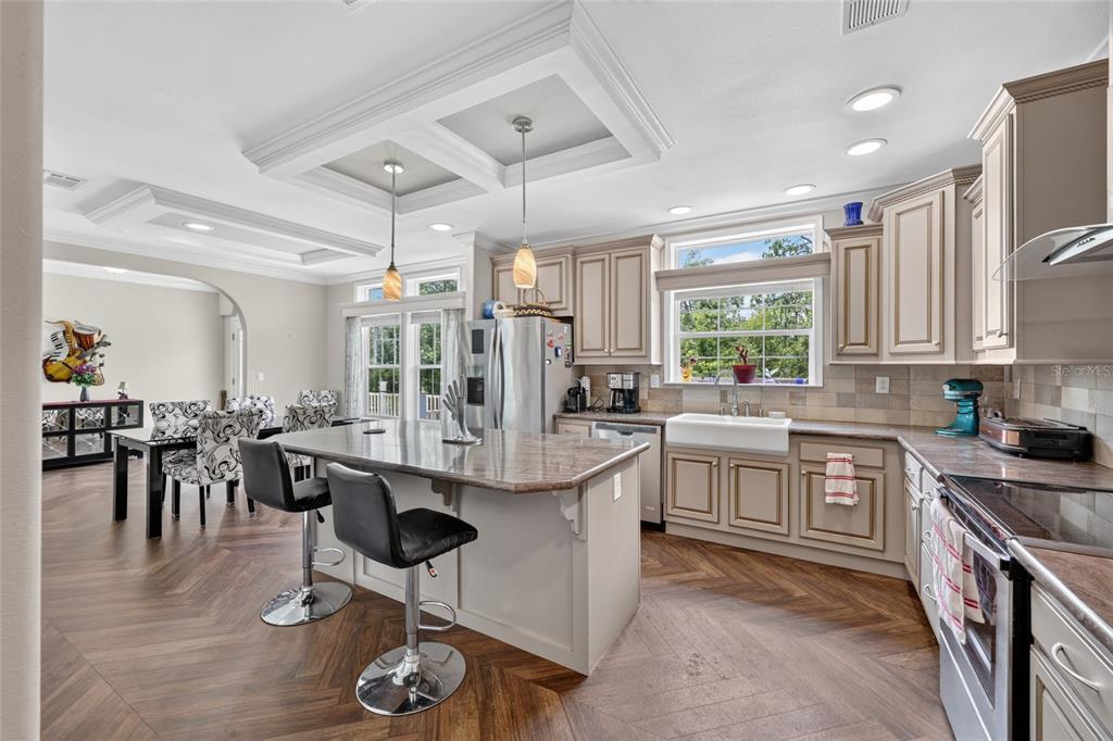 A kitchen with a central island, farmhouse sink, and herringbone wood flooring — 7131 NE 138TH TERRACE, WILLISTON, FL