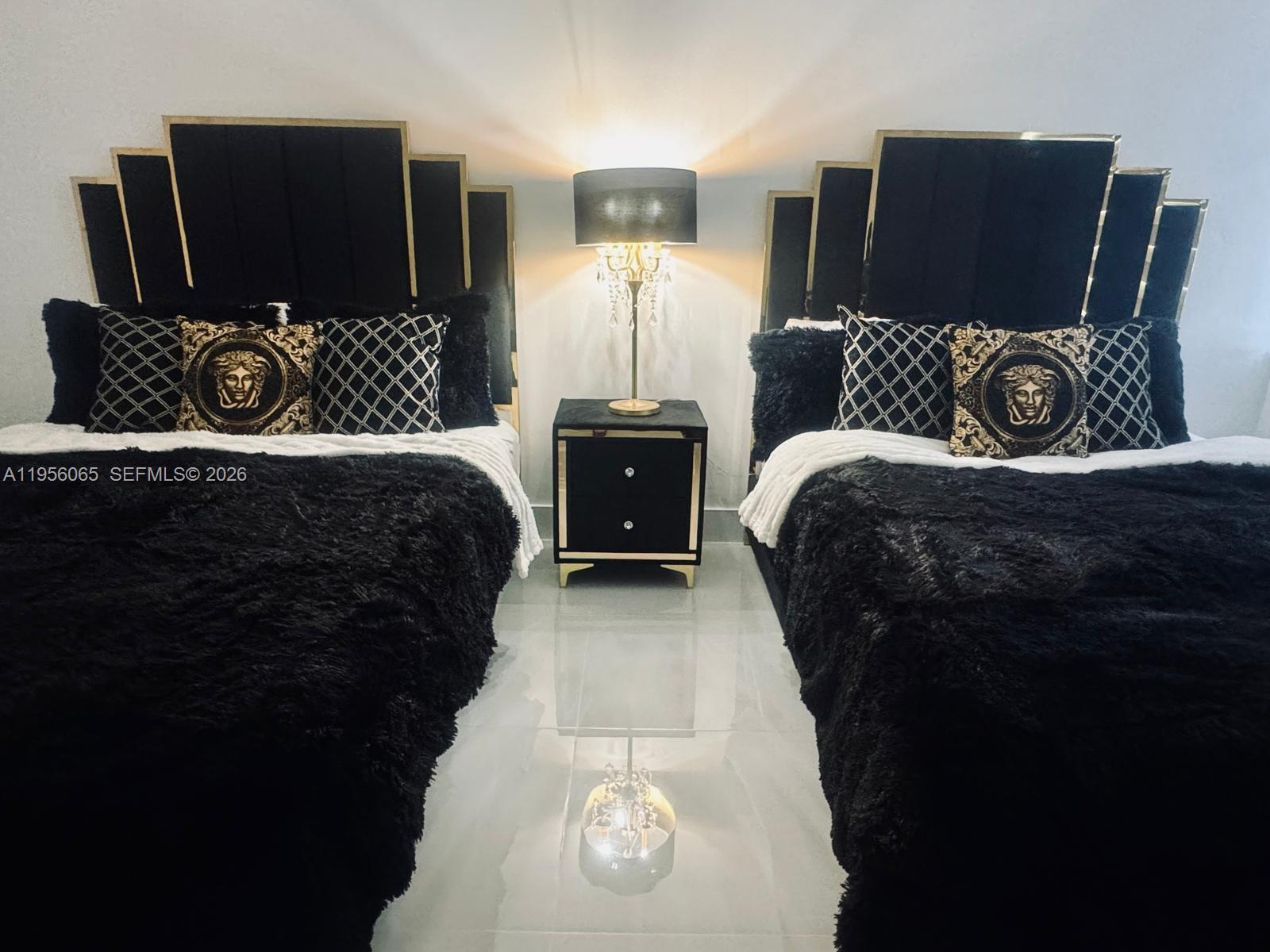 A bedroom features two beds with black headboards and matching nightstands on a tiled floor — 100 Lincoln Rd # 408, Miami Beach FL 33139, MIAMI BEACH, FL