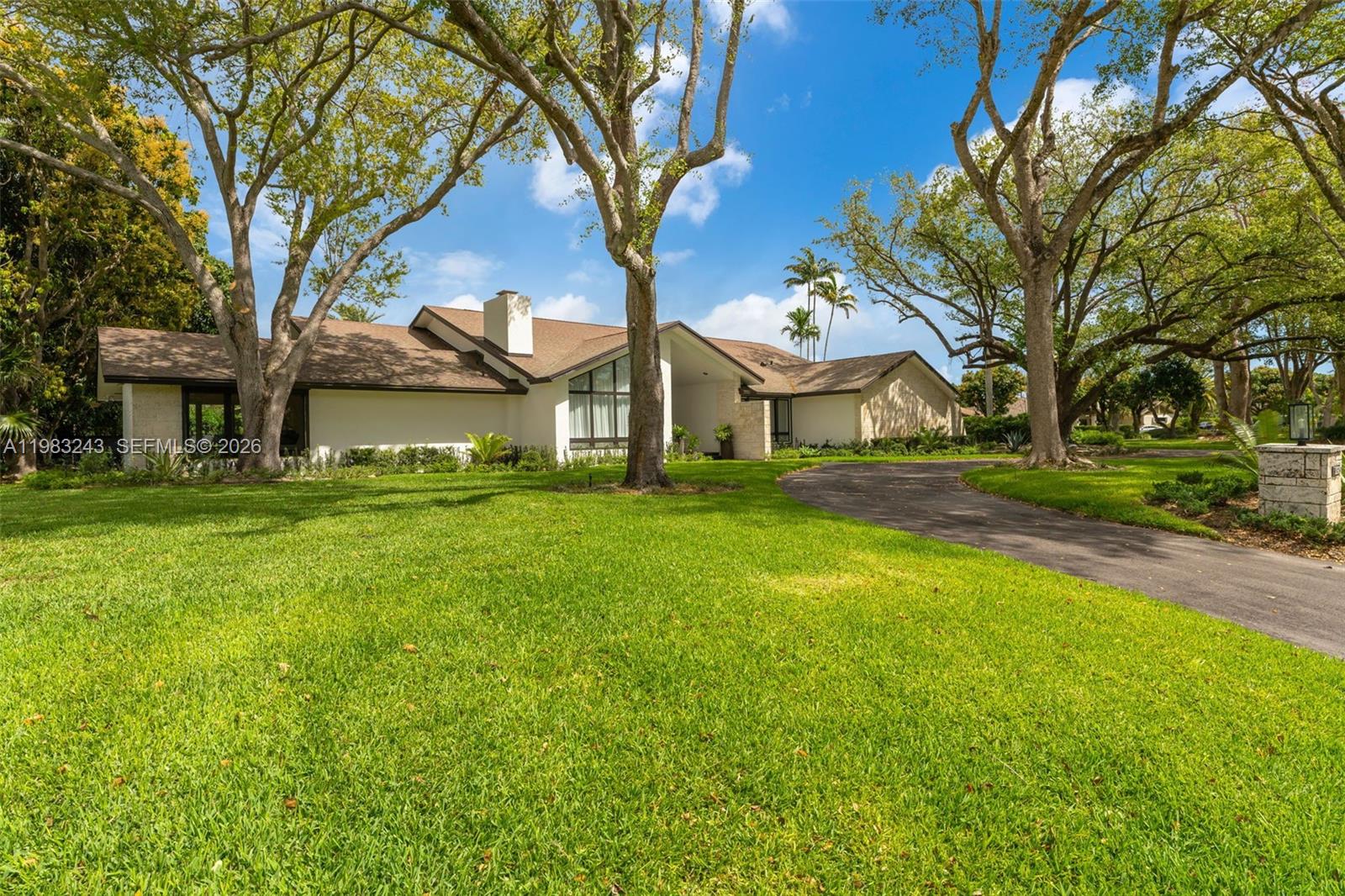 A single-story house with a brown roof and a paved driveway sits on a lawn — 8967 SW 117th St, Miami FL 33176, MIAMI, FL