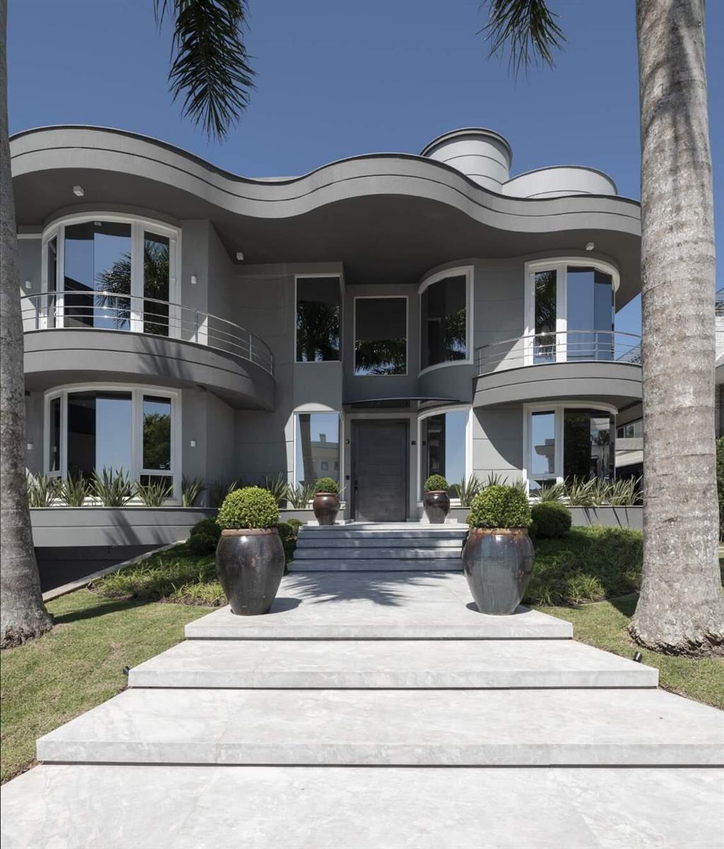 A modern two-story gray house features a curved roofline, balconies, and a stone walkway — 44 Rua Das Pirapemas Street # 44, FL