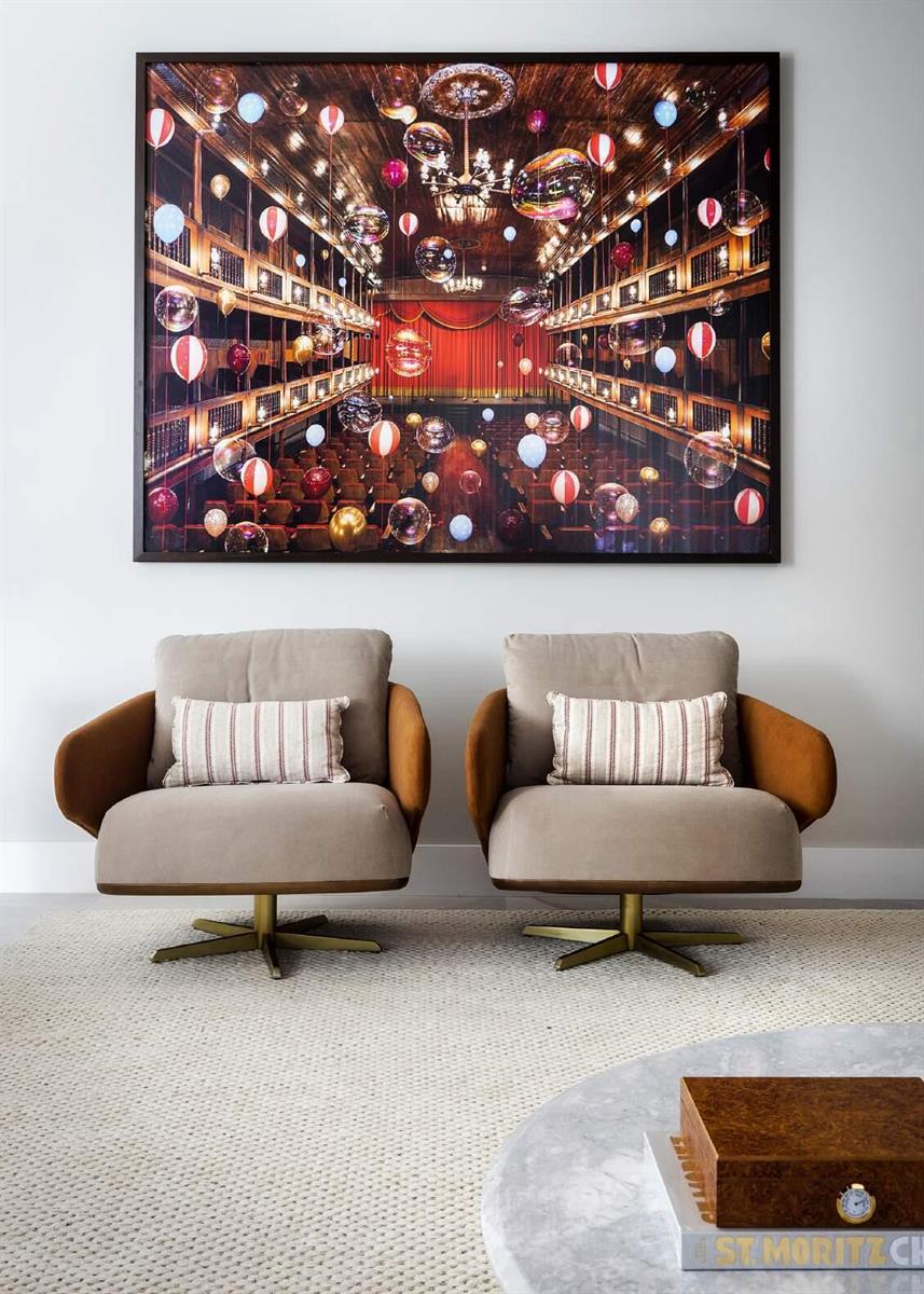 Two beige armchairs sit on a light rug beneath a large framed theater photograph — 44 Rua Das Pirapemas Street # 44, FL