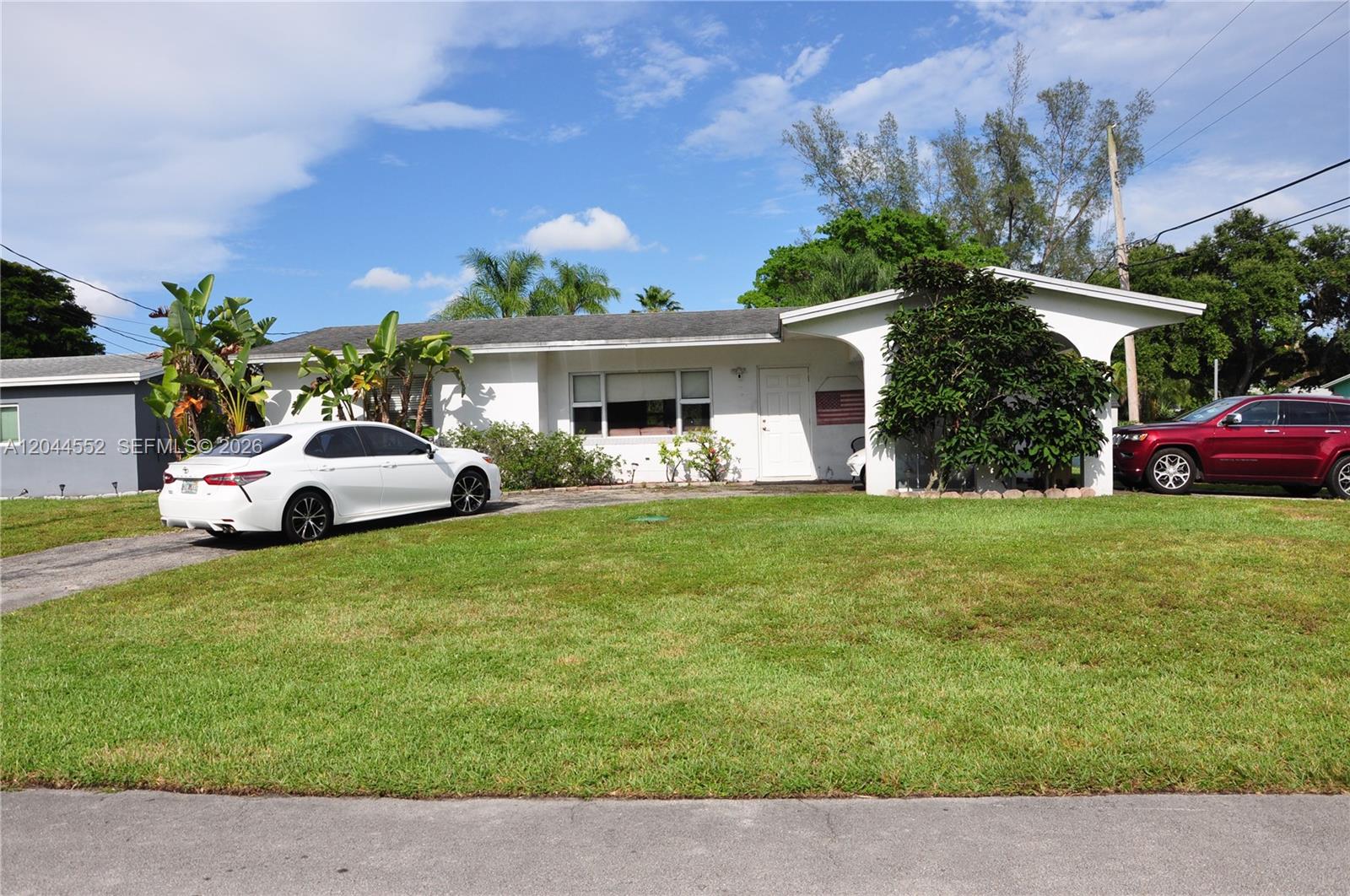 A white single-story house features a front lawn, a driveway, and a covered entryway — 5630 SW 55th Ave, Davie FL 33314, DAVIE, FL