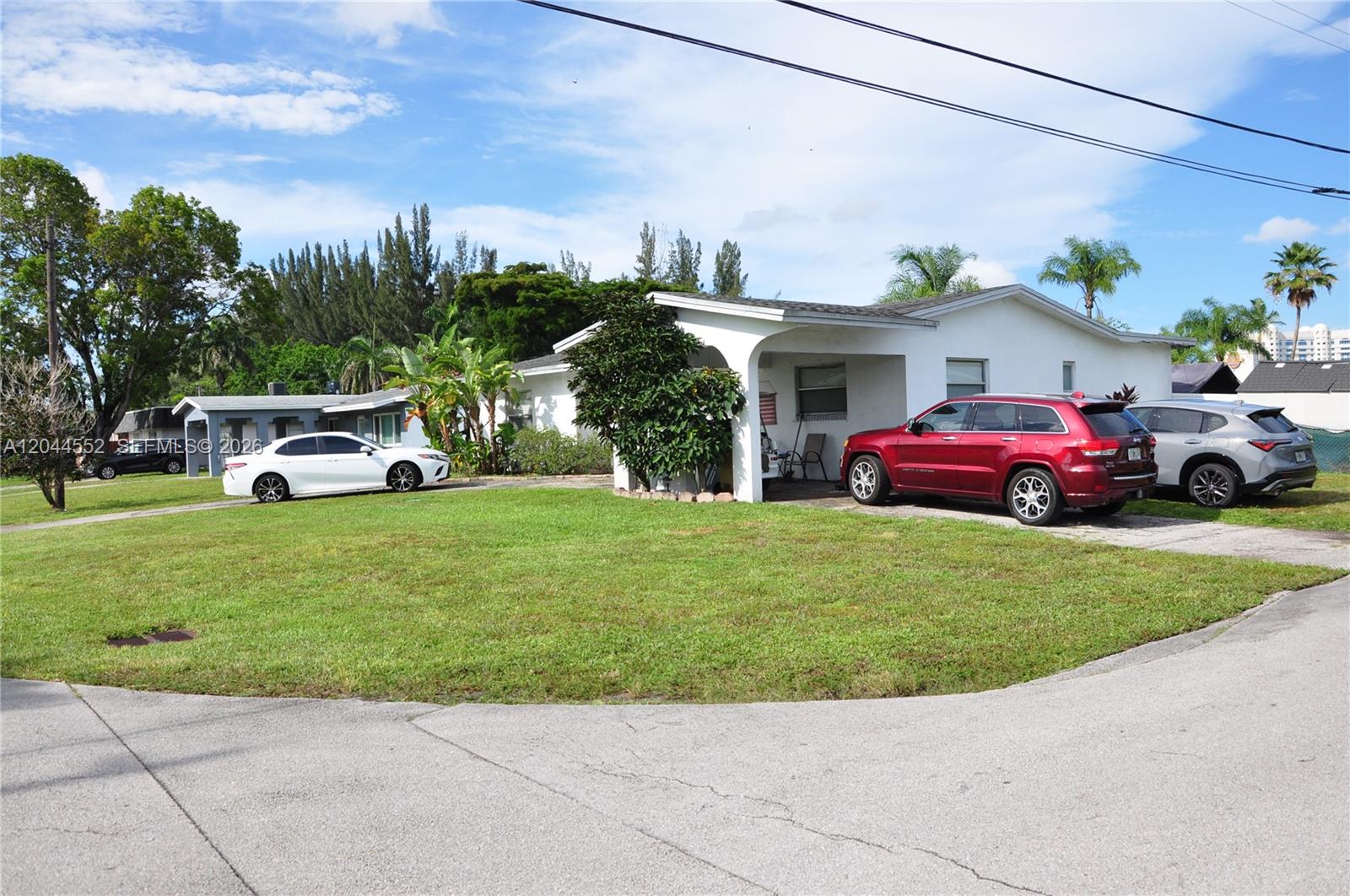A white single-story house with a covered porch and three cars parked in the driveway — 5630 SW 55th Ave, Davie FL 33314, DAVIE, FL