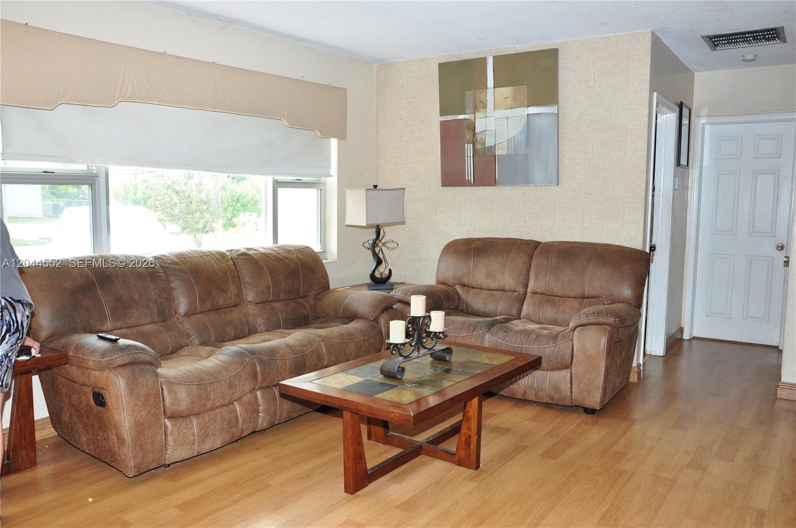 A living room features two brown leather sofas, a coffee table, and wood-look flooring — 5630 SW 55th Ave, Davie FL 33314, DAVIE, FL