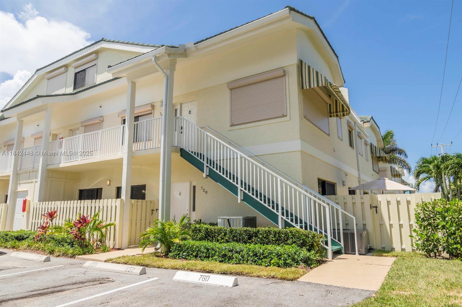 An exterior view of a two-story residential building with an outdoor staircase and parking spaces — 720 S Bella Vista Ct S # 20, Jupiter FL 33477, JUPITER, FL