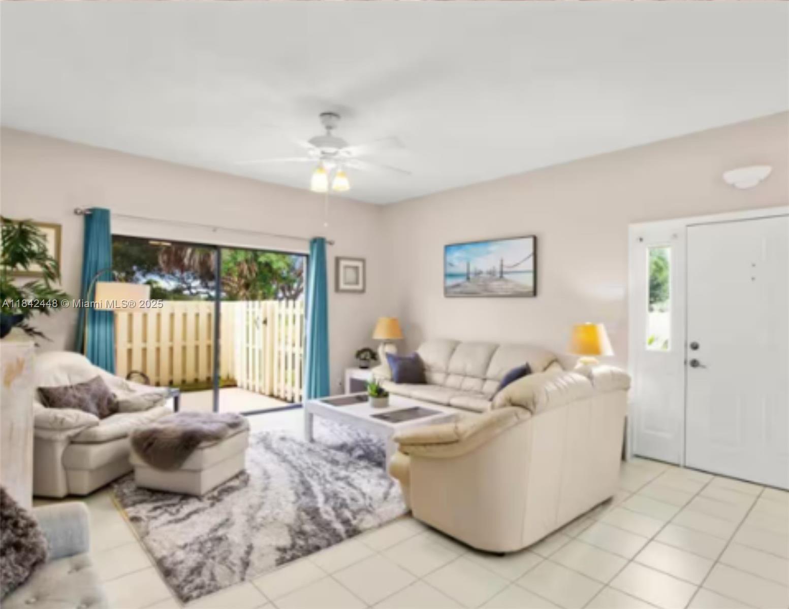 A living room features light-colored tile floors, a white sofa set, and a sliding glass door — 720 S Bella Vista Ct S # 20, Jupiter FL 33477, JUPITER, FL