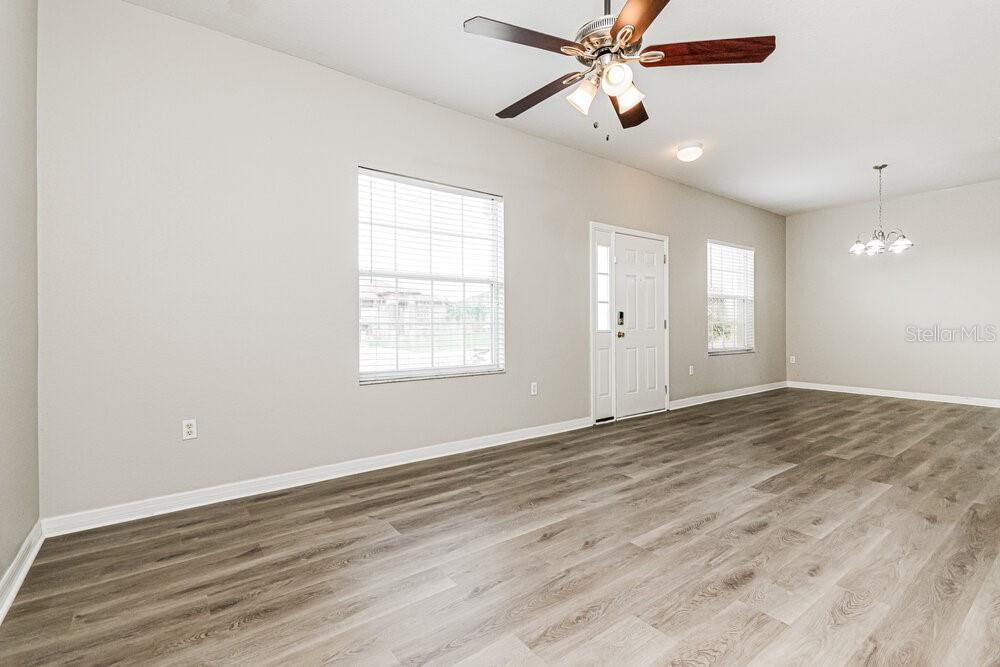 An empty room with light gray walls, wood-look flooring, a ceiling fan, and a door — 292 CLOVERDALE ROAD, WINTER HAVEN, FL
