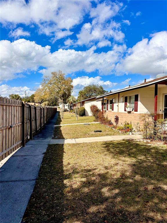 A wooden fence runs alongside a grassy yard leading to a single-story residential building — 712-A E ARIZONA AVENUE UNIT A, DELAND, FL