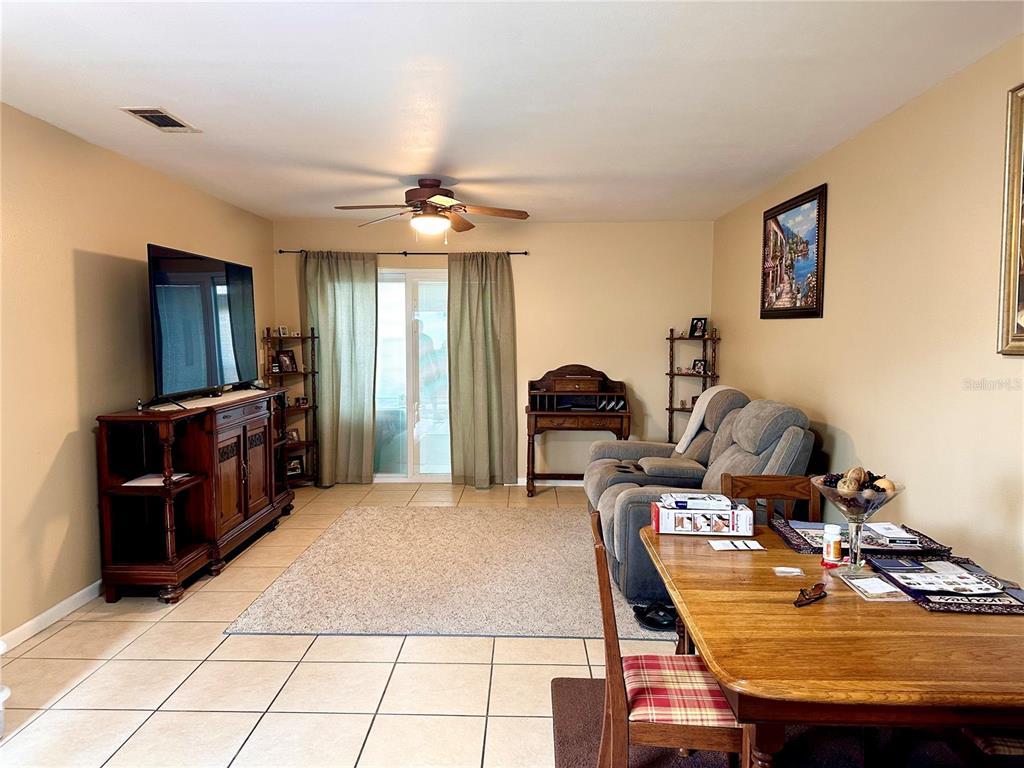 A living room features tile flooring, a ceiling fan, a television console, and a sofa — 712-A E ARIZONA AVENUE UNIT A, DELAND, FL