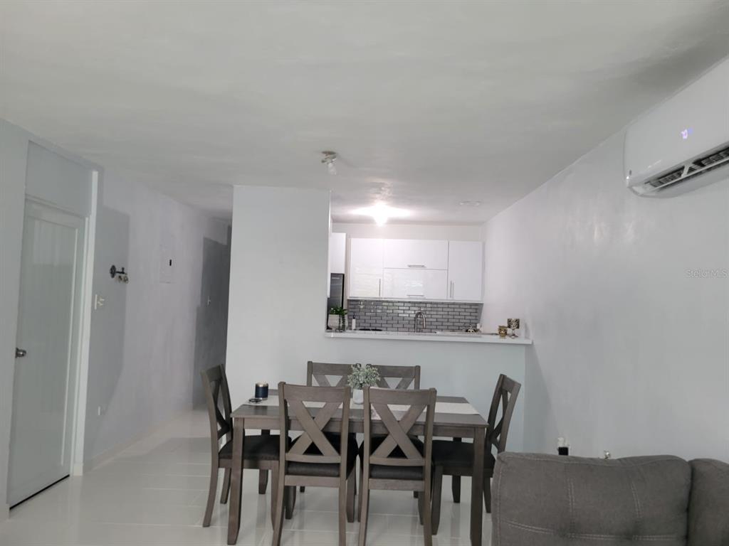A dining area with a wooden table and chairs sits in front of an open kitchen — B4 ST GUATEMALA UNIT B4, HUMACAO, PR