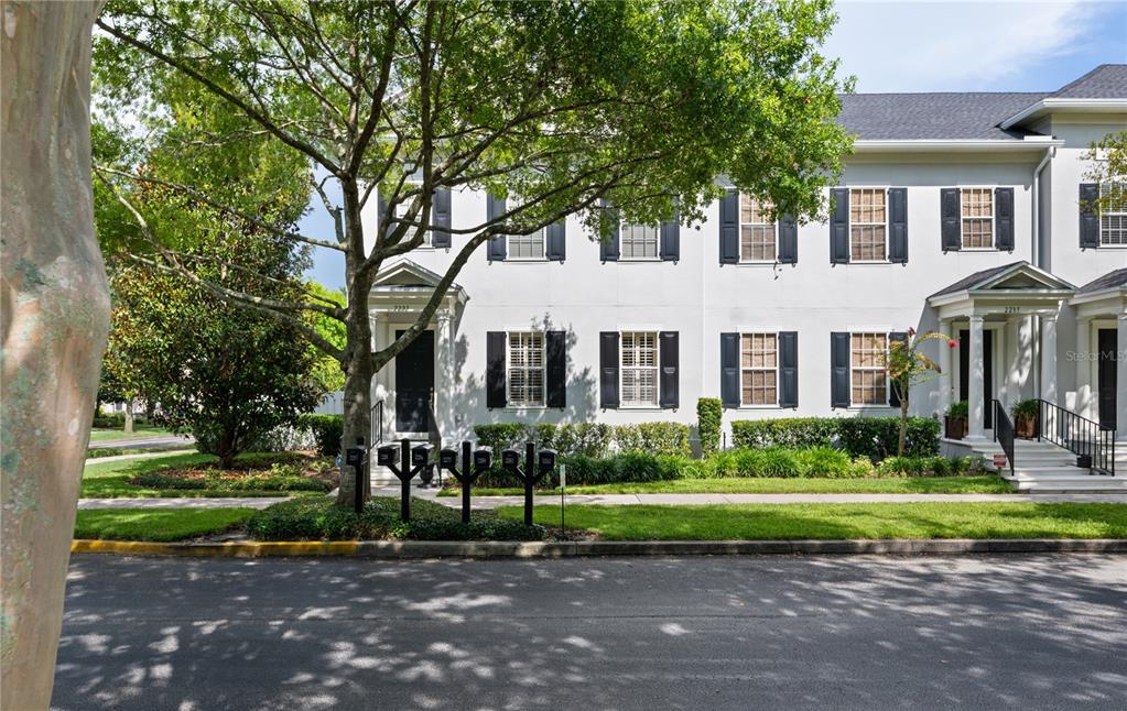 A multi-story townhouse exterior with white siding, black shutters, and a row of mailboxes — 2293 OSPREY AVENUE, ORLANDO, FL