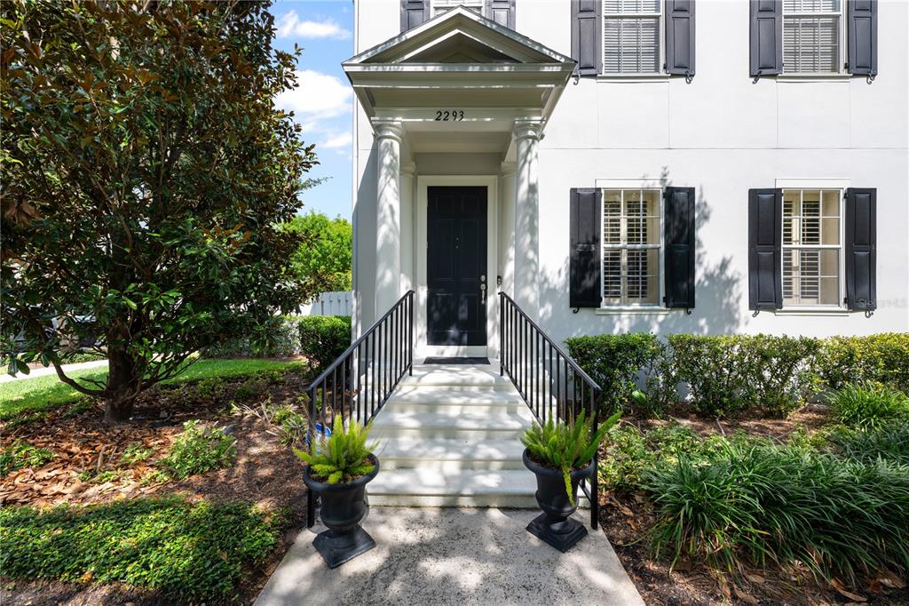 A white house exterior features a black front door, columns, and a small staircase — 2293 OSPREY AVENUE, ORLANDO, FL