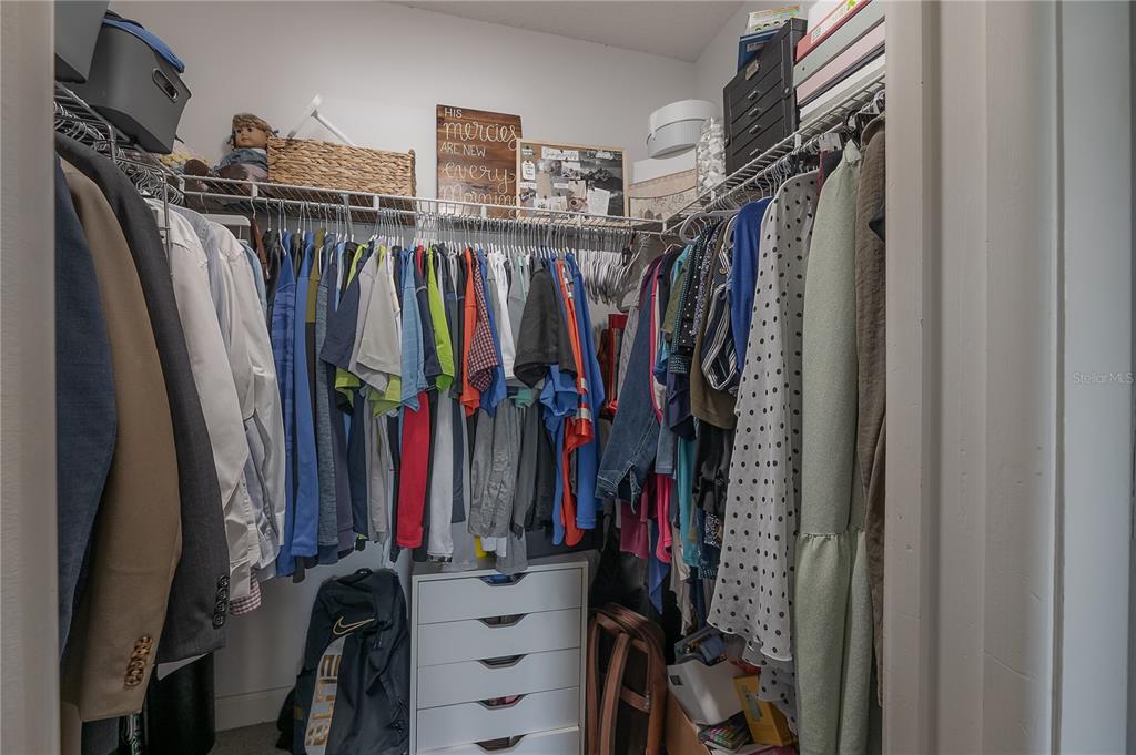 A walk-in closet features hanging clothes, a white drawer unit, and upper storage shelves — 13210 WHALER DRIVE, HUDSON, FL