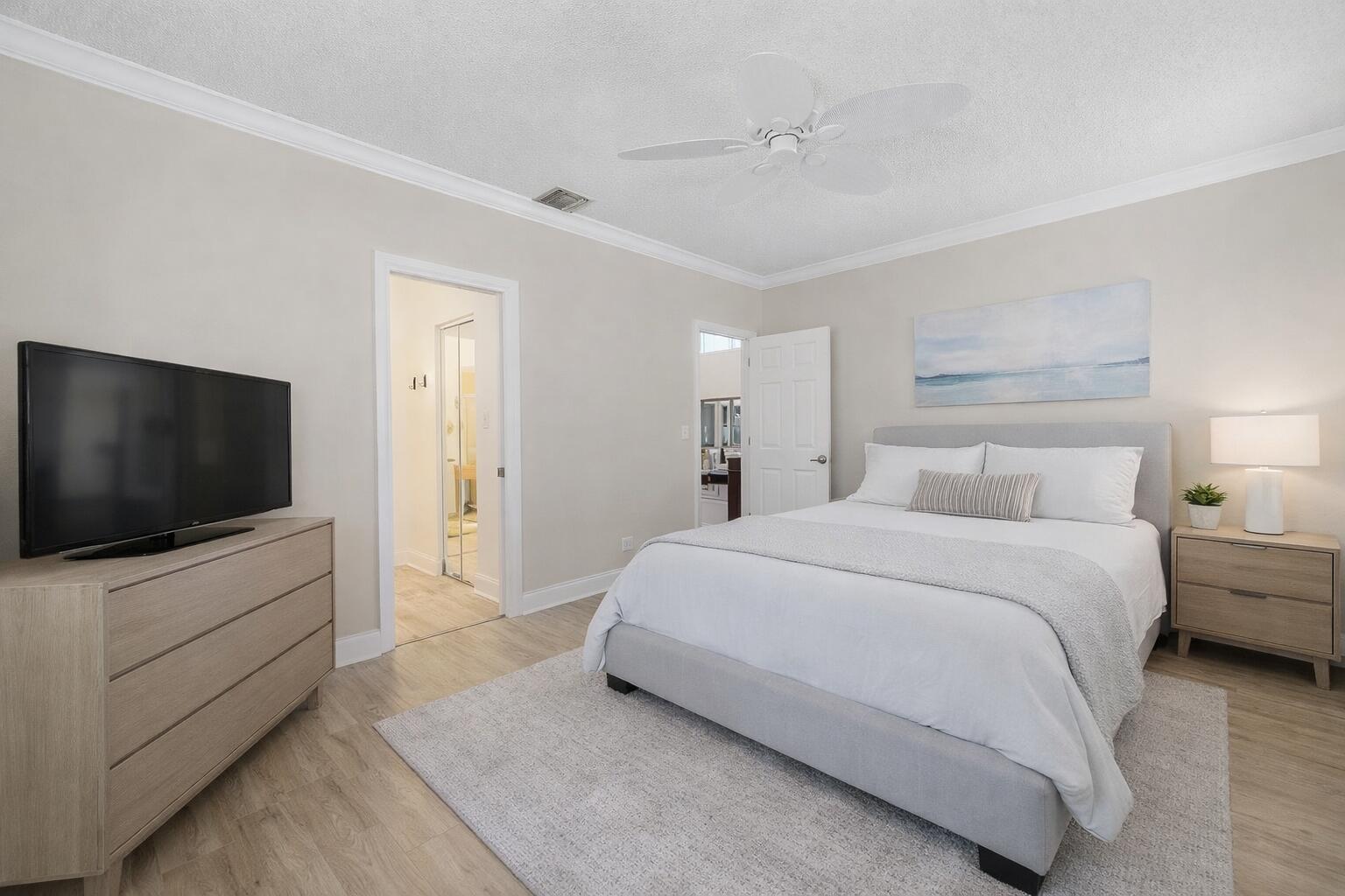 A bedroom with light wood flooring, a gray upholstered bed, a dresser, and a ceiling fan — 3000 Conifer Drive, Fort Pierce FL 34951, FORT PIERCE, FL