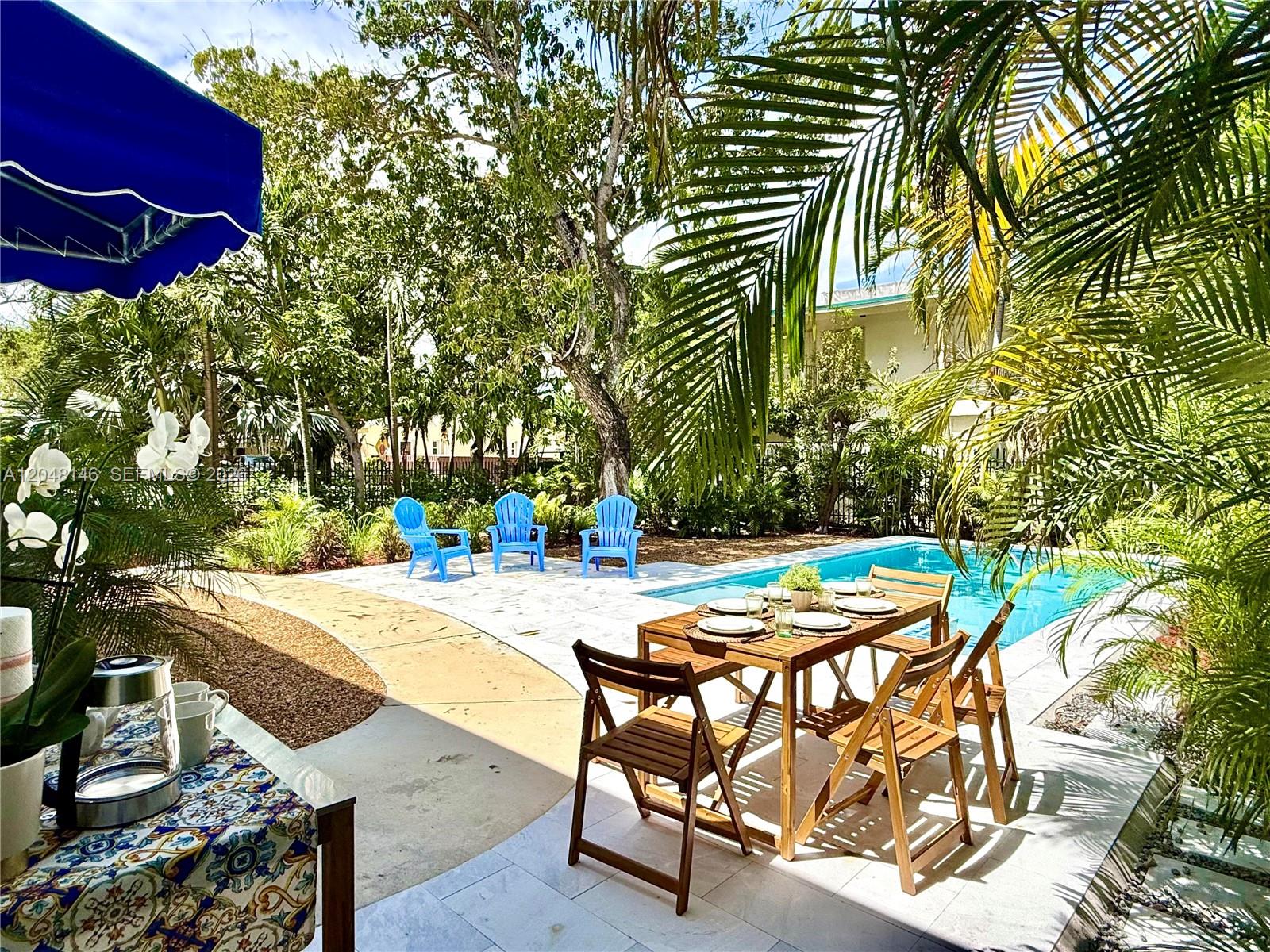A backyard patio features a dining set, blue Adirondack chairs, and a swimming pool — 1345 SW 14th Ave, Miami FL 33145, MIAMI, FL