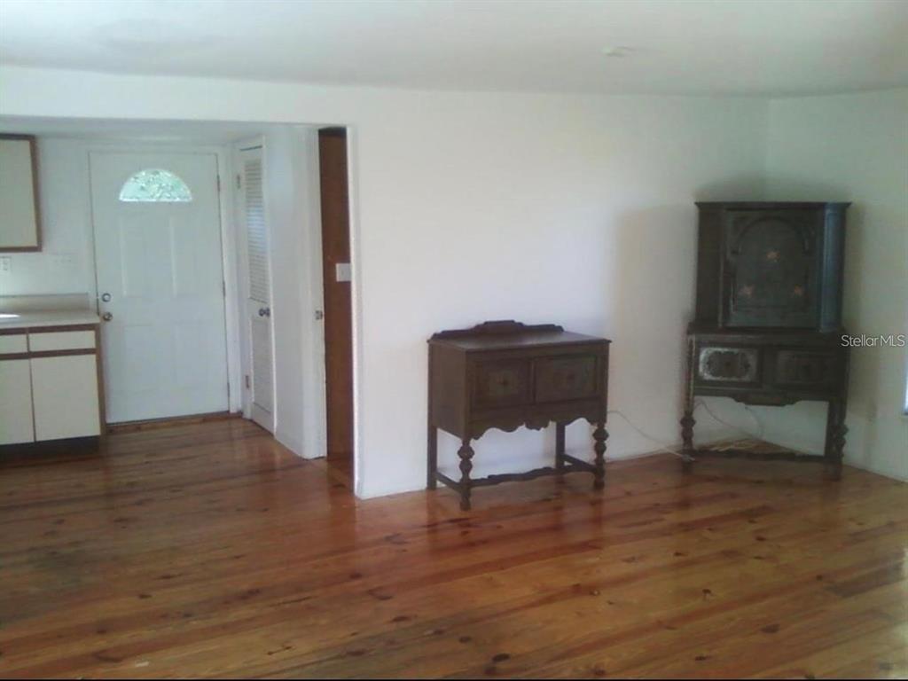A room with hardwood floors, white walls, a doorway, and two antique wooden cabinets — 7205 S MANHATTAN AVENUE, TAMPA, FL