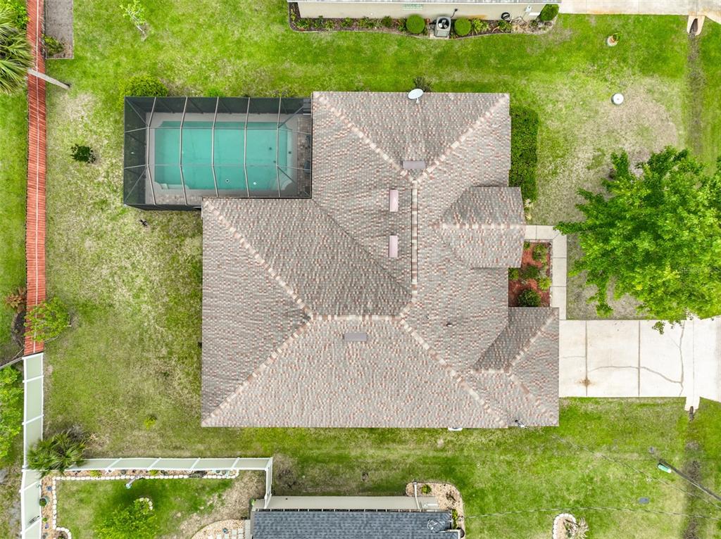 An aerial view shows a house with a tiled roof, a screened pool, and landscaping — 6 EVANSVILLE LANE, PALM COAST, FL