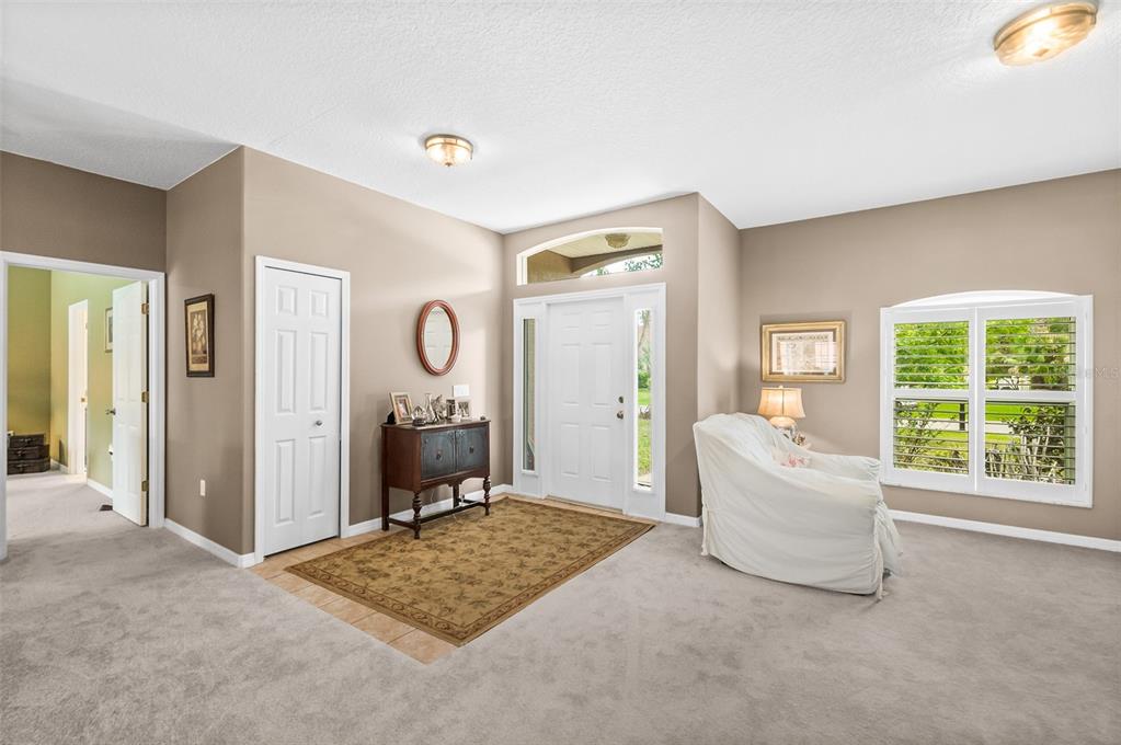A carpeted entryway features a tiled rug area, a wooden console table, and a front door — 6 EVANSVILLE LANE, PALM COAST, FL